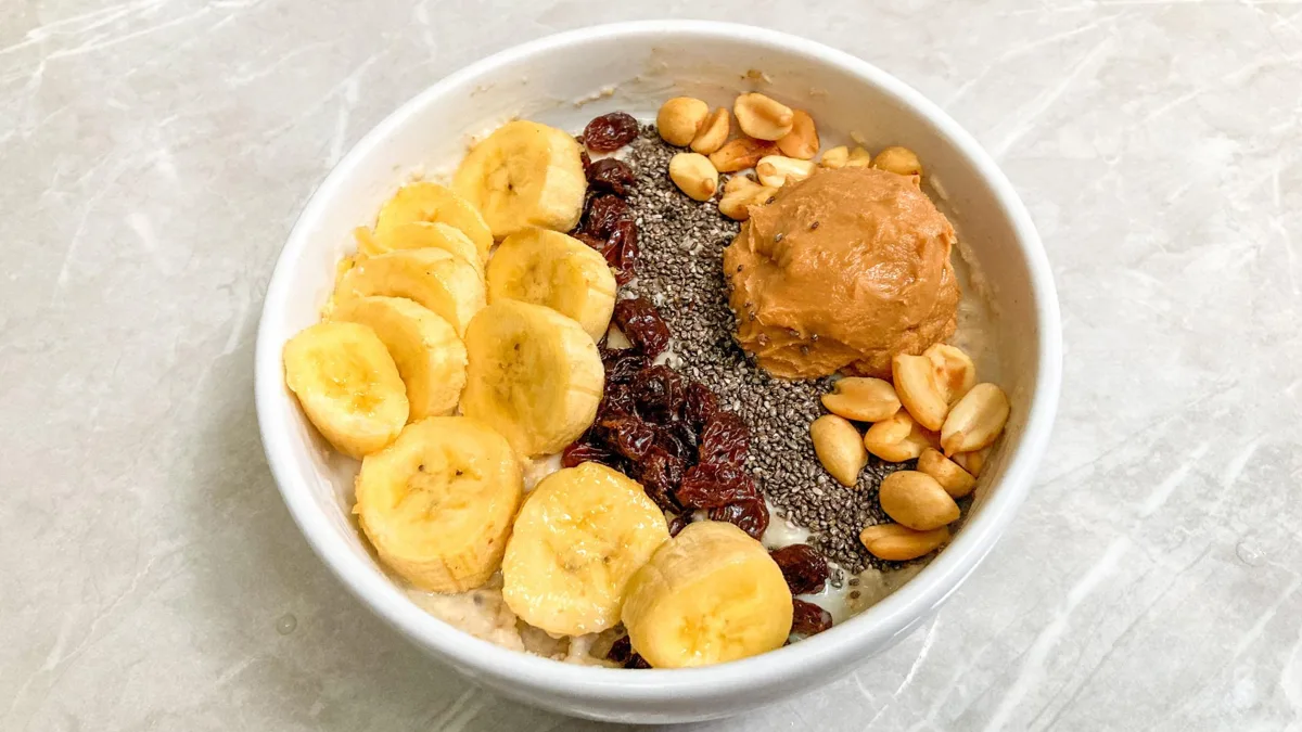 Bol de flocons avec rondelles de banane, graines de chia, cacahuètes et beurre de cacahuète