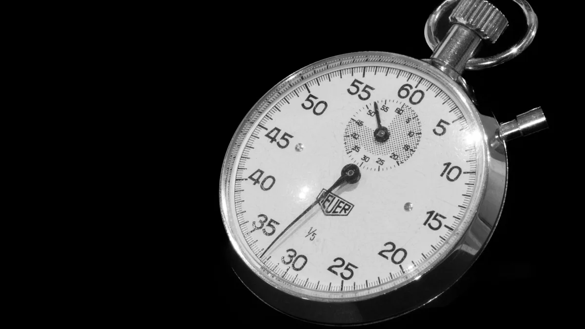 Chronomètre mécanique ancien à cadran blanc sur fond noir