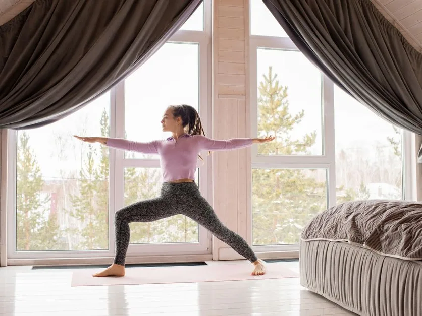 Personne qui s’étire au calme sur un tapis, après la séance